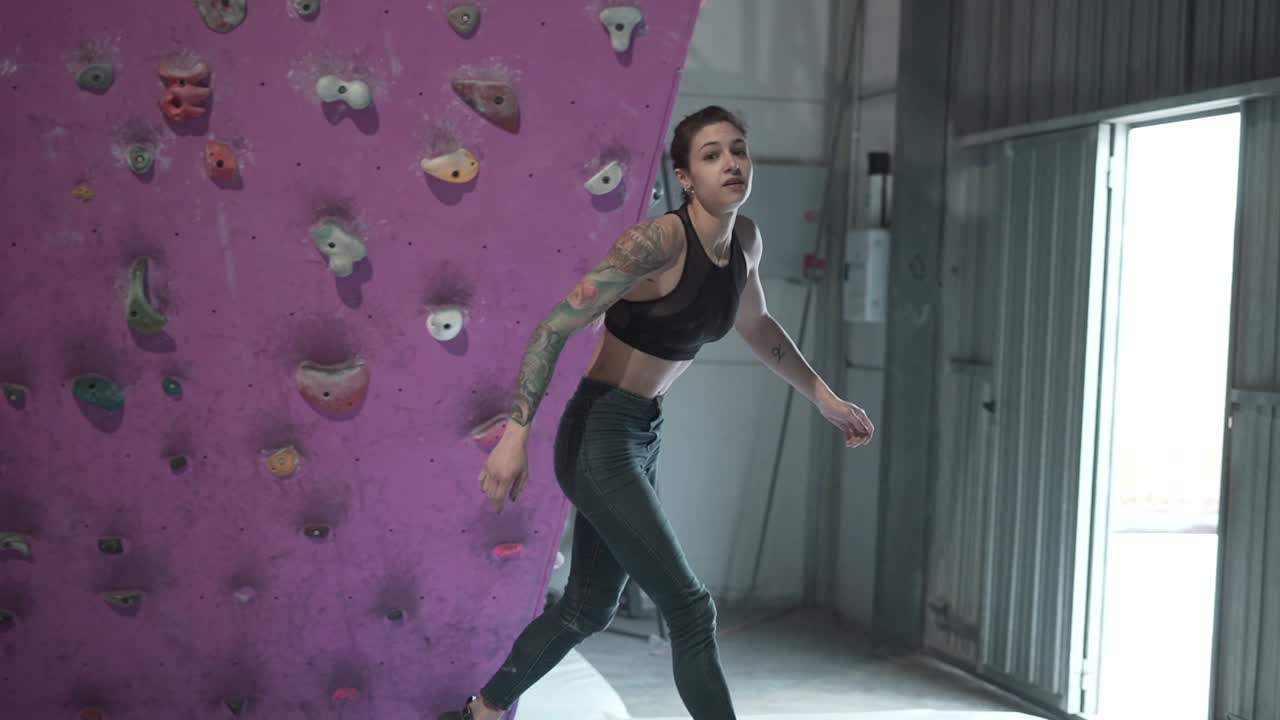 mujer escalando roca en un gimnasio de escalada cubierto