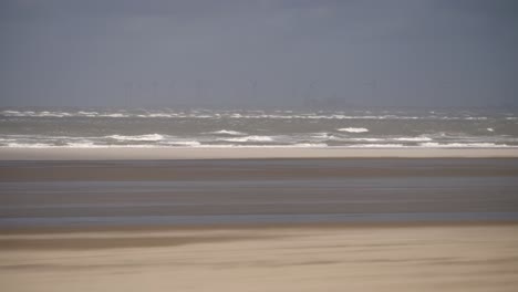 Storm-on-the-coast,-shifting-sand-over-the-beach