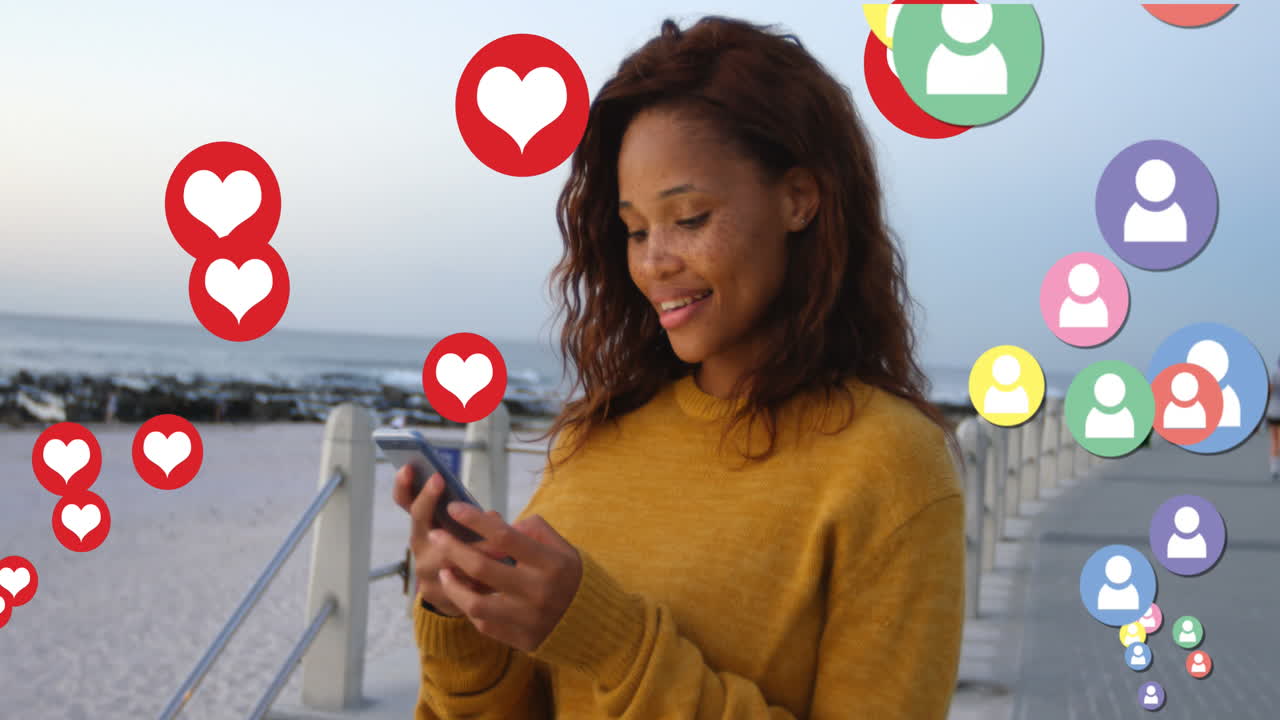 Multiple profile and red heart icons floating against woman using smartphone