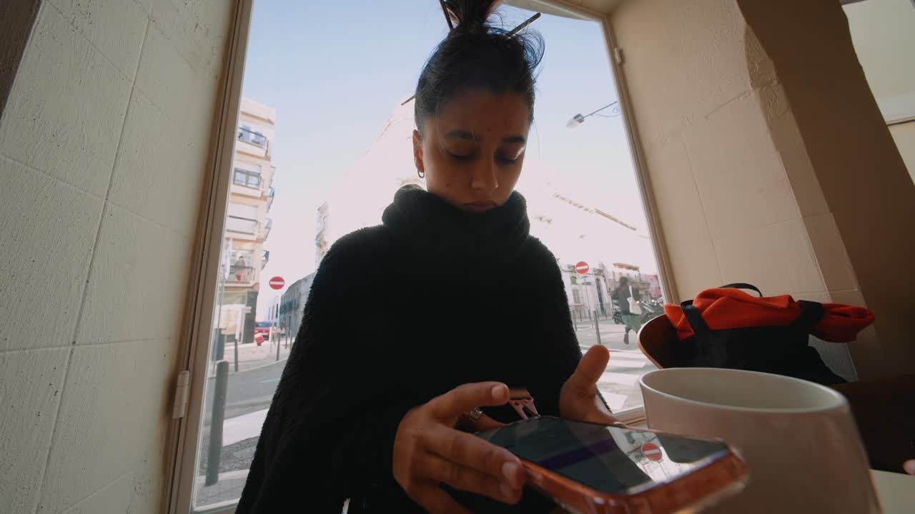 A woman using her phone in a cafe