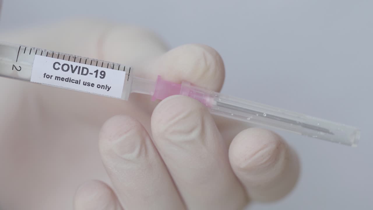 covid-19 solo para uso médico: la mano del médico puso la aguja con tapa en la jeringa