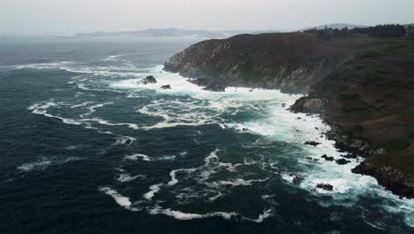 Panoramablick-Auf-Meereswellen,-Die-Auf-Felsige-Klippen-In-Der-Nähe-Des-Küstenparks-In-Caion-Beach,-Coruna,-Spanien,-Treffen