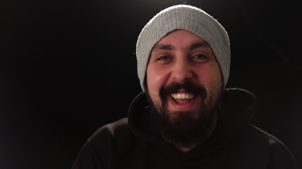 Man laughing and smiling in a gray beanie