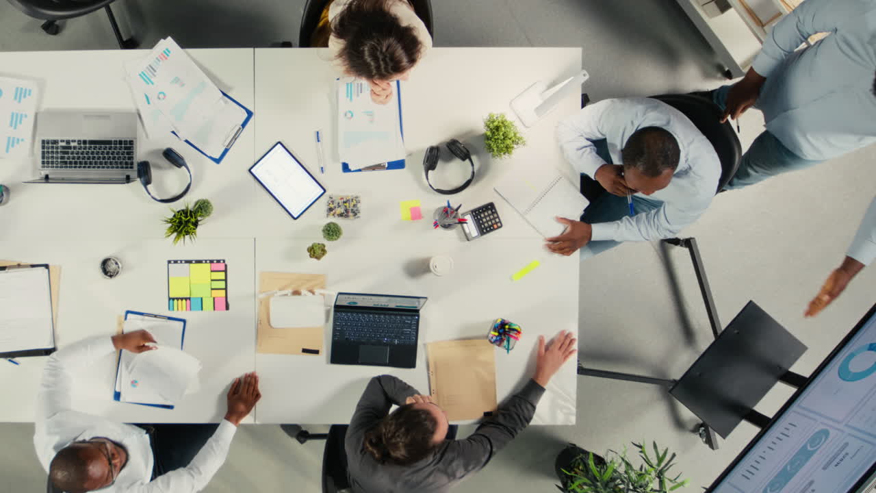 Top down view zoom out of business colleagues share insight on finances