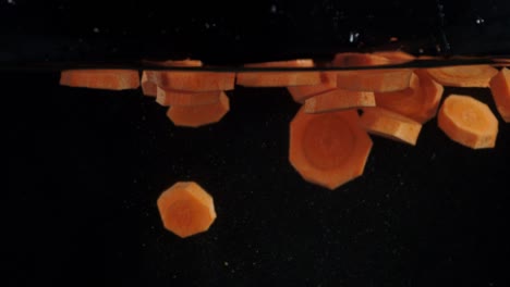 fall pieces of carrot under water with air bubbles.