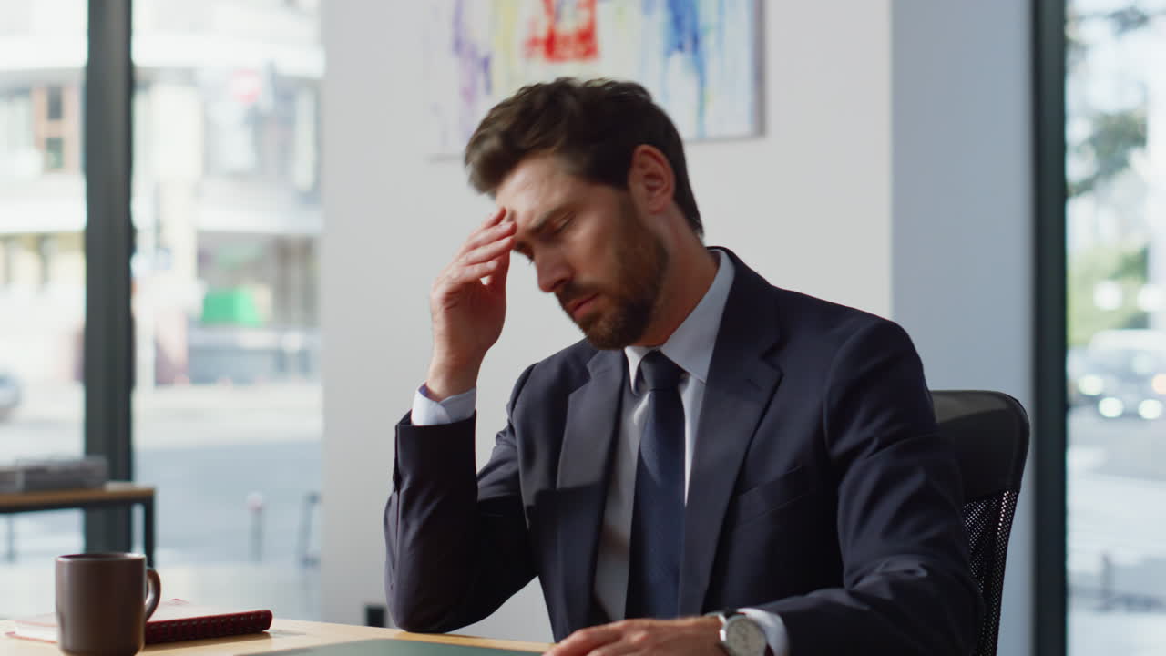 Serious man typing computer keyboard closing laptop at light workplace ...