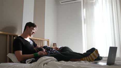 familia relajándose en la cama viendo la computadora portátil