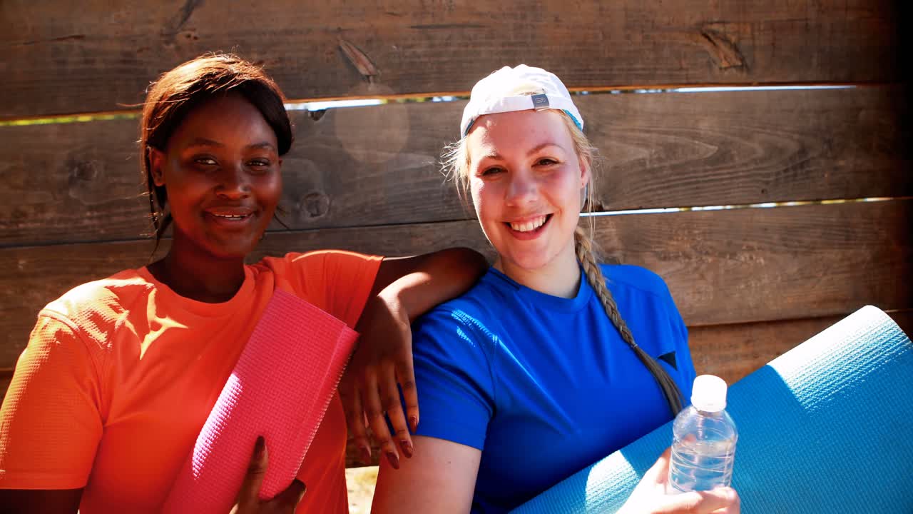 retrato de amigos felices relajándose después del entrenamiento durante una carrera de obstáculos