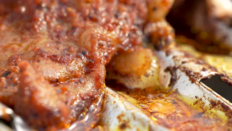 marinated chicken meat drilled on barbecue metal grid, bubbling hot oil close-up