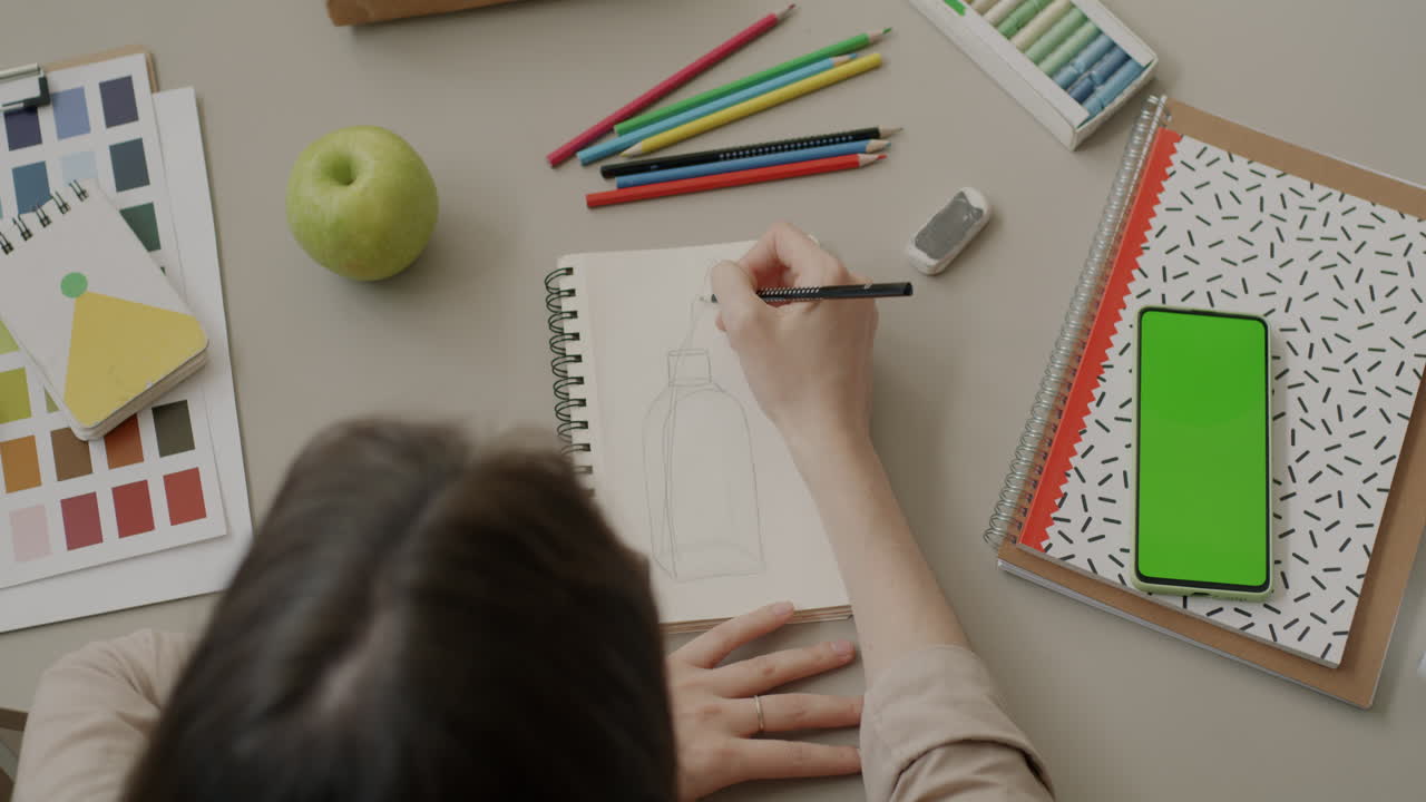 Woman drawing a sketch of a bottle