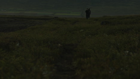 people walking away from camera while hiking in mountains of iceland