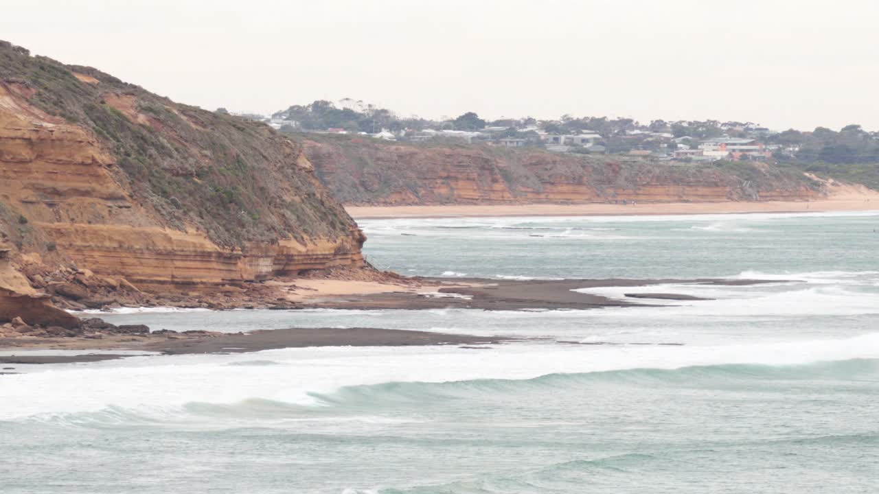 Waves crashing against rocky cliffs at Bell Beach