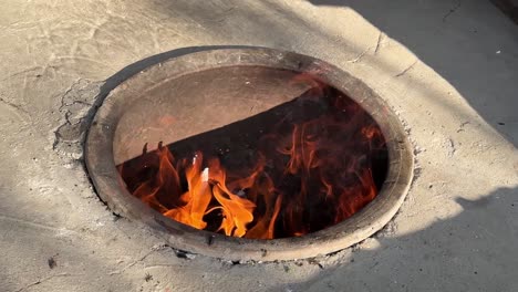 wood fire using dry tree branches in rural village country life in iran to make turkish persian bread by fermentation of wheat flour dough and kneading before put in clay oven traditional bakery skill