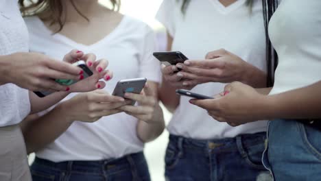 disparo en primer plano de manos femeninas escribiendo en teléfonos inteligentes
