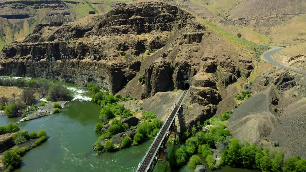 US, Oregon, Maupin, Deschutes River, 2025-05-08 - Drone view on the Deschutes River of a train bridge at Twin Crossings which is two bridges and a tunnel. In north central Oregon in spring