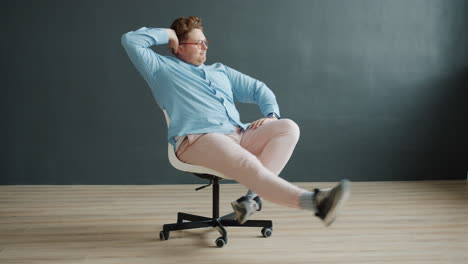 man sitting in an office chair in a funny pose