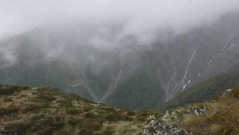 waterfalls running down mountain edges at brewster track in mount aspiring national park, new zealand