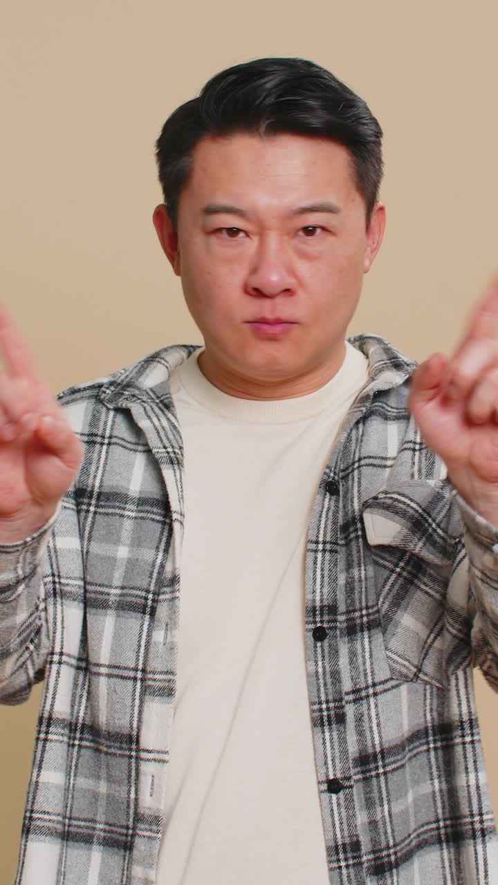 Frightened asian man closing mouth with hands refusing to tell terrible secret unbelievable truth