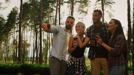 personas sonrientes haciendo selfies en el móvil en el patio trasero. chicos divirtiéndose al aire libre