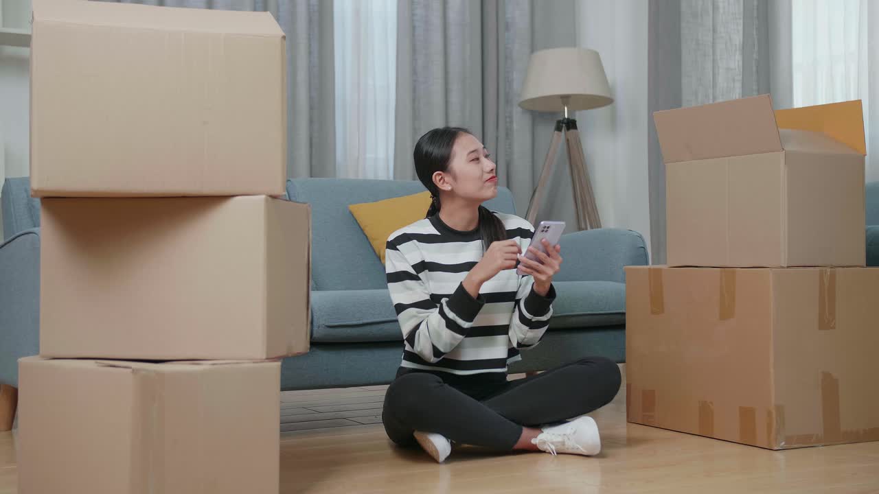 집 을 옮기는 동안 전화 를 사용하는 여자