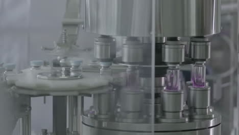 modern technology, glass vials filled with medical liquid on a automated pharmaceutical production line in sterile environment
