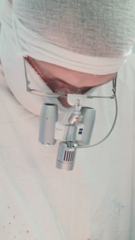 surgeons with binoculars perform surgery. doctor removes chest tube with instrument preparing patient for closing incision in operating room