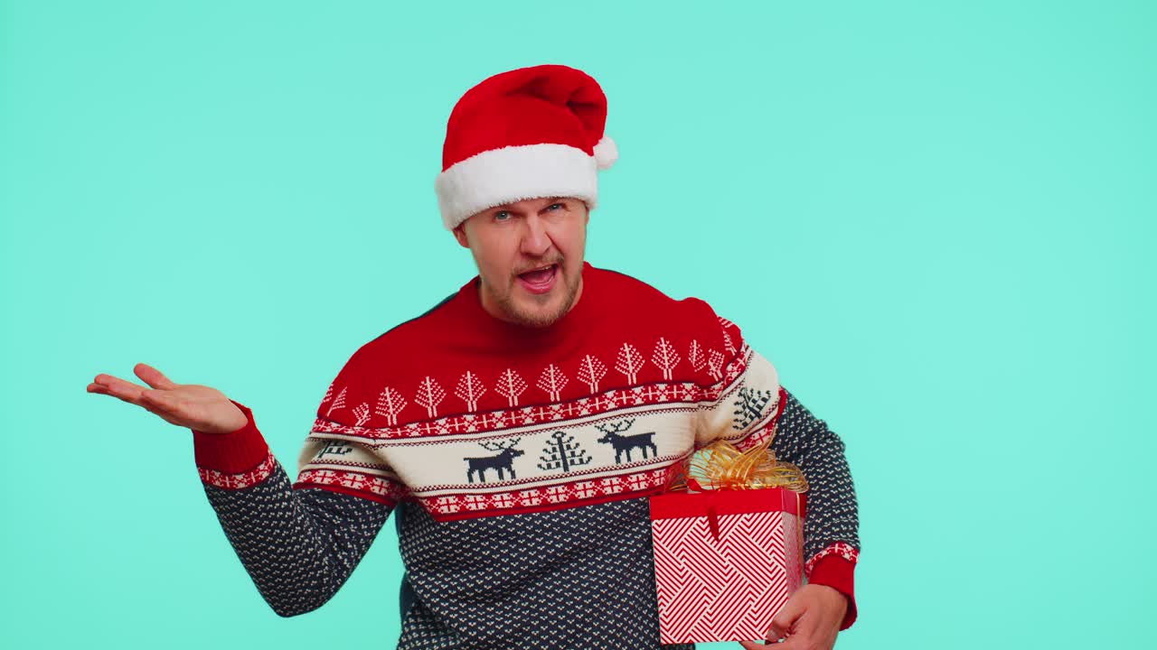 Man in christmas sweater pointing at camera showing stupid gesture blaming some idiot for plan