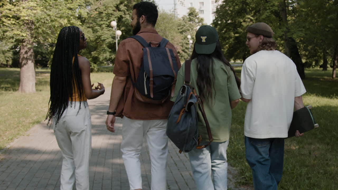 Group of young friends walking through a park on a sunny day