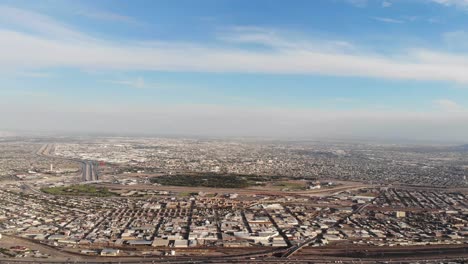 Slowly-rising-aerial-drone-shot-of-El-Paso,-Texas,-looking-across-the-US-Mexico-border-and-into-Juarez,-Mexico