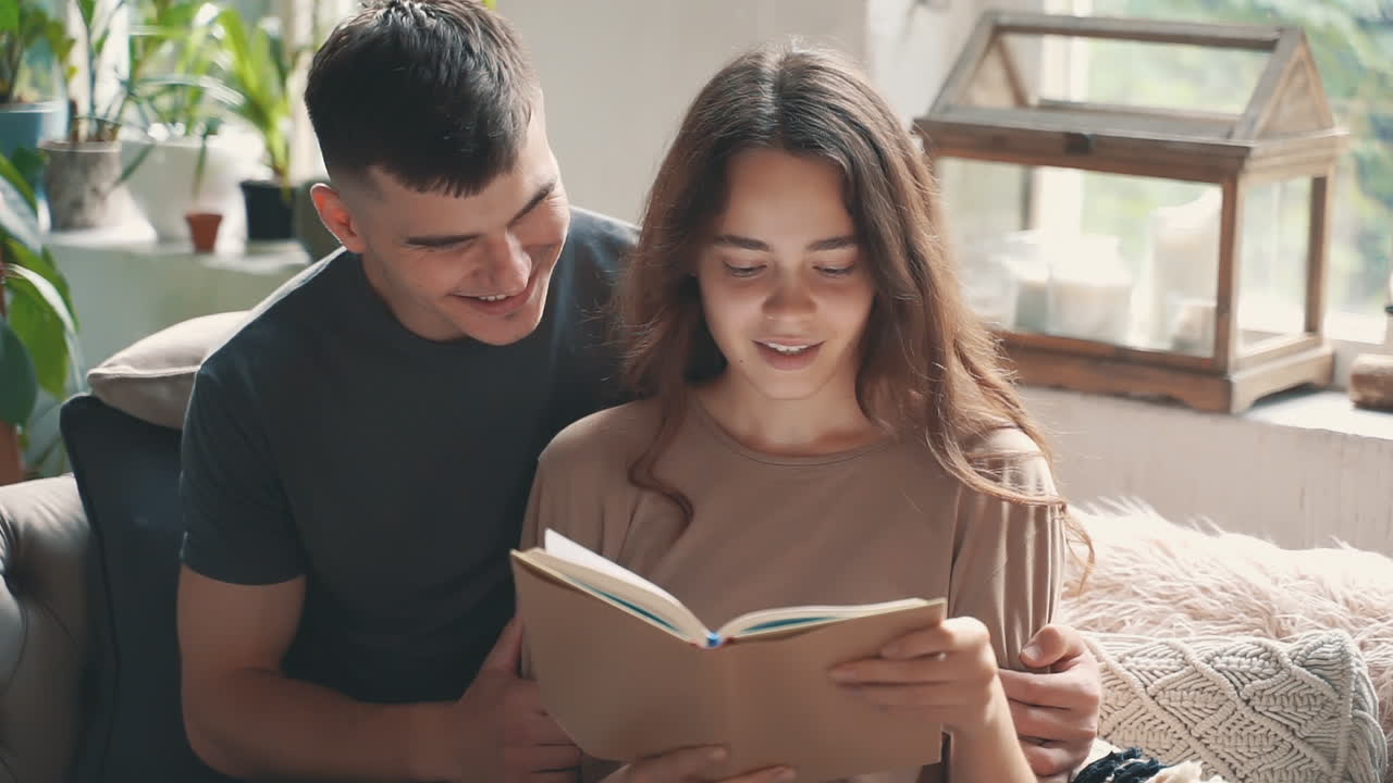 jóvenes amantes mujer y hombre leen un libro juntos
