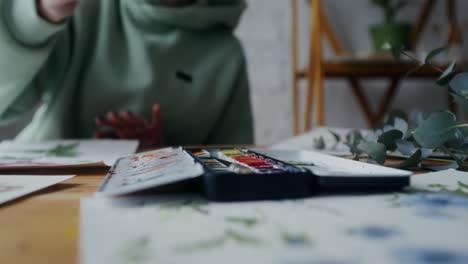 woman painting watercolor flowers