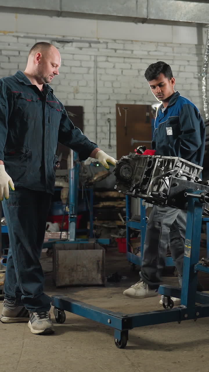 ingenieros mecánicos en un taller de automóviles, uno con guantes rojos trabajando en un motor de coche mientras el colega observa, el fondo presenta coches estacionados, herramientas y equipos de taller