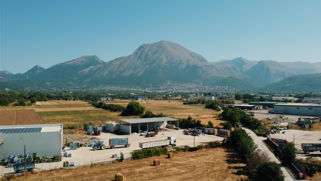 Rural landscape with mountains, fields, and industrial elements