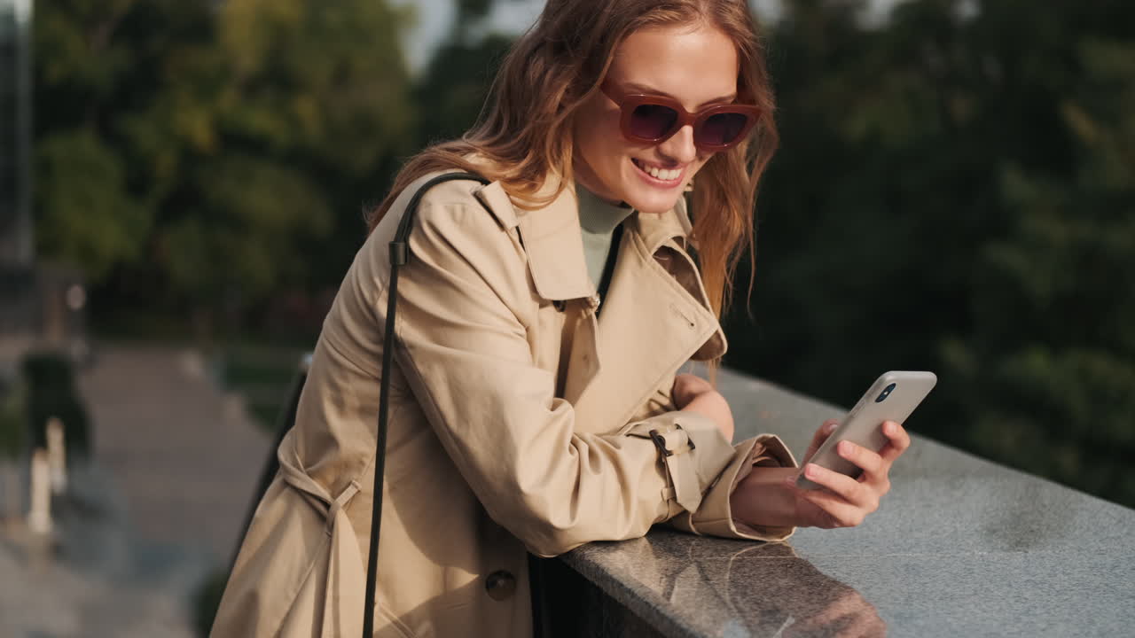 Caucasian female student using smartphone outdoors.
