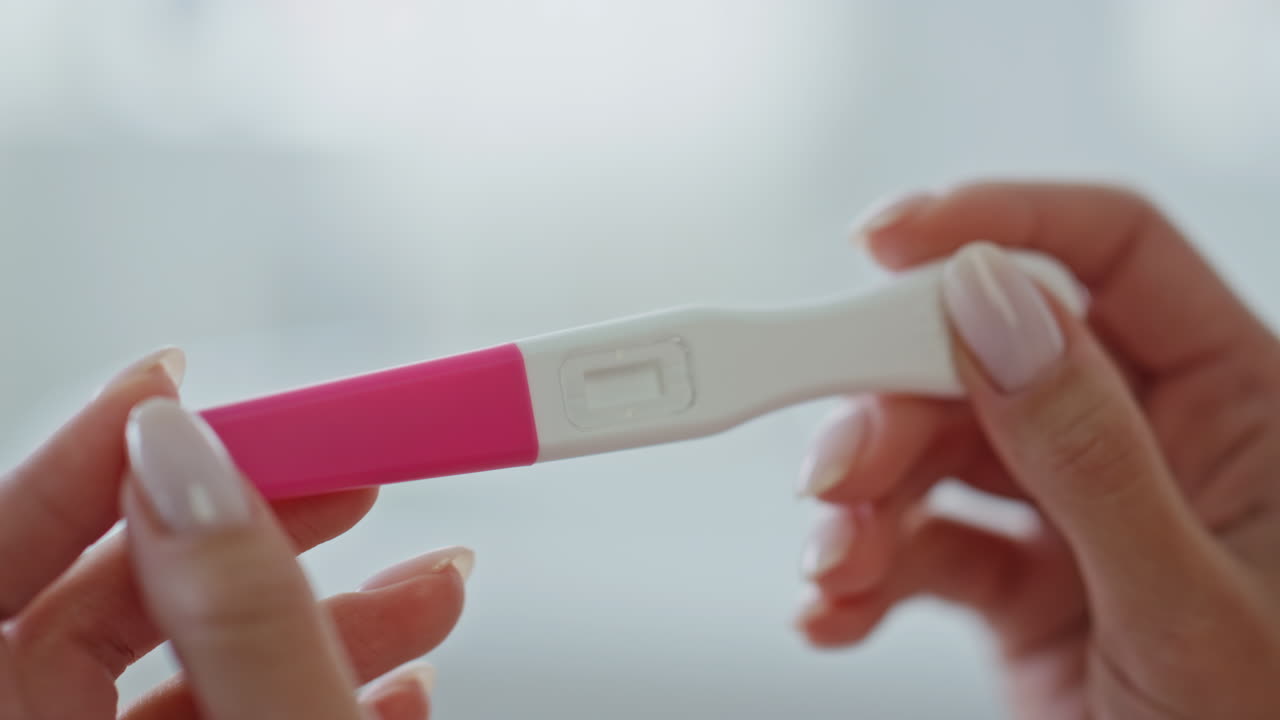 Manos de chica esperando el resultado de la prueba de embarazo en casa. Mujer mirando el kit de prueba vacío.