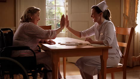 a nurse and an elderly woman high-fiving while playing a game