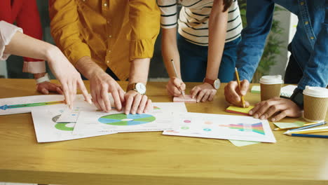 close up view of papers and documents with charts, graphics and diagrams on a wooden desk in office