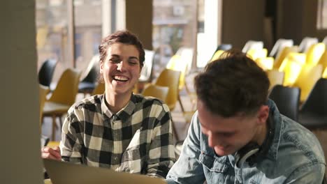 couple of two young people are laughing together while discussing something. indoors footage. love, romantic feelings, youth.