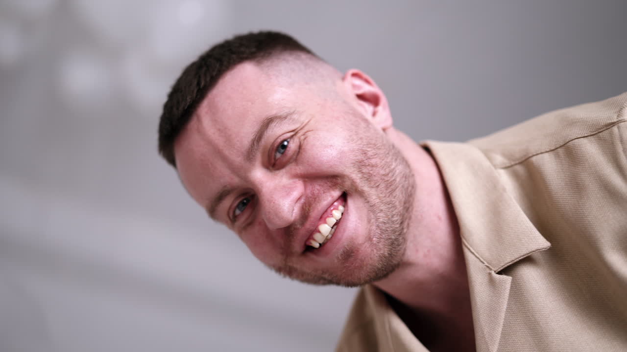 Smiling Caucasian man feeling happy. Man holding a cake with one candle. First year anniversary, celebration. Low angle view.