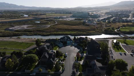 Suburban-neighborhood-along-the-Jordan-River-Parkway-in-Lehi,-Utah---pullback-aerial-reveal