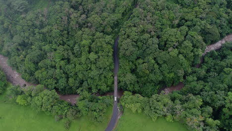 wide overhead aerial of car crossing bridge as drone ascends into clouds, 4k