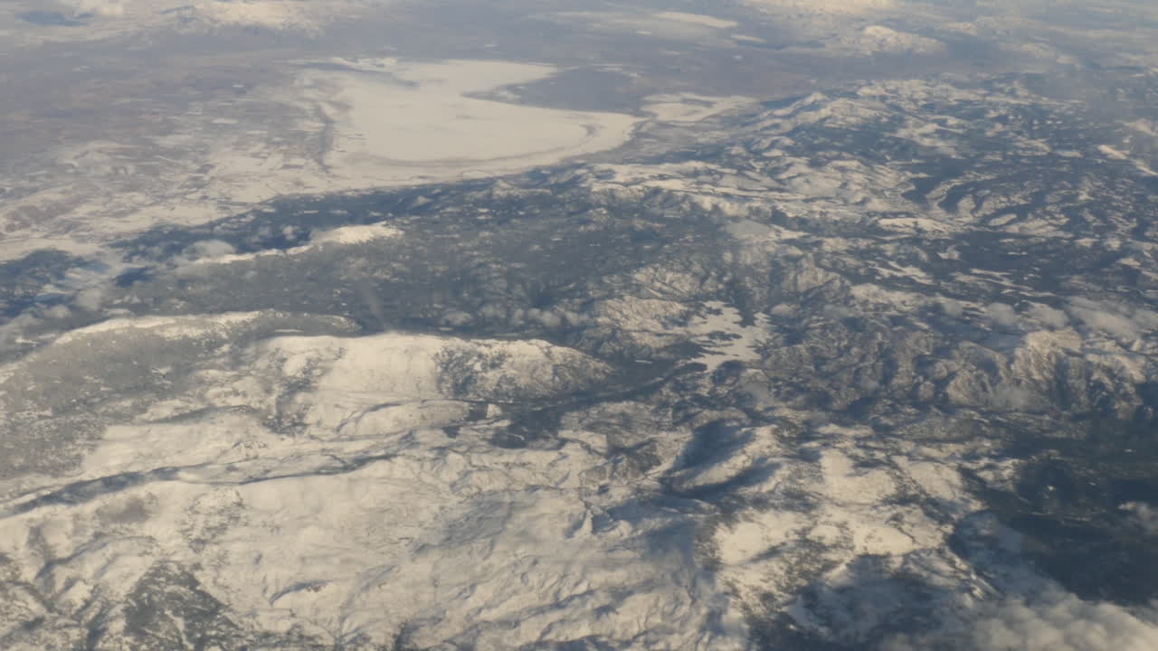 vista aérea de las montañas cubiertas de nieve de oregon con nubes fuera de la ventana del avión filmada en alta resolución 4k