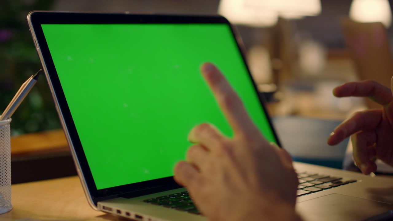 manos de hombre usando una maqueta de computadora. tipo irreconocible haciendo una videollamada en el interior.