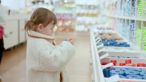 Beautiful-Little-Child-Taking-Toy-From-The-Box-At-The-Shelf-In-Shopping-Mall