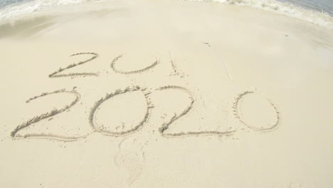 2020 written in sand on beach