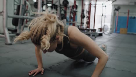 Mujer-Ejercitando-Saltos-Dinámicos-En-El-Suelo-Del-Gimnasio.