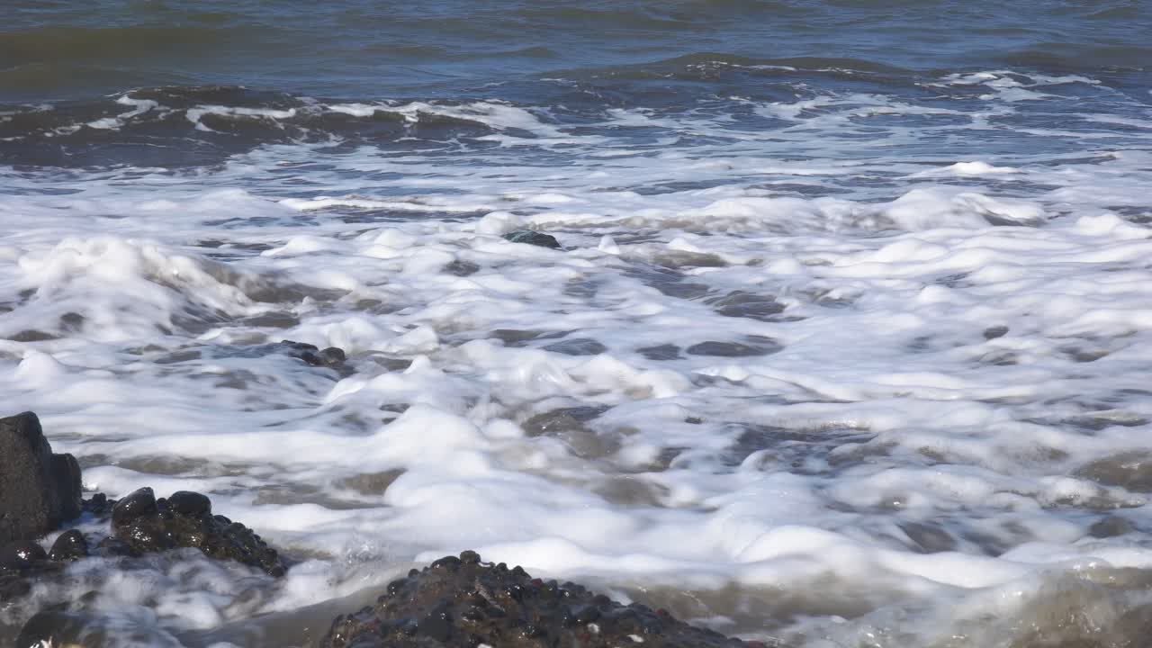 primo piano delle onde sulla spiaggia durante il giorno