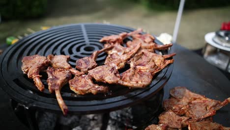 ribs being cooked on a round barbecue grill