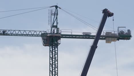 crane operating at a construction site in argentina, with a high-rise building in the background