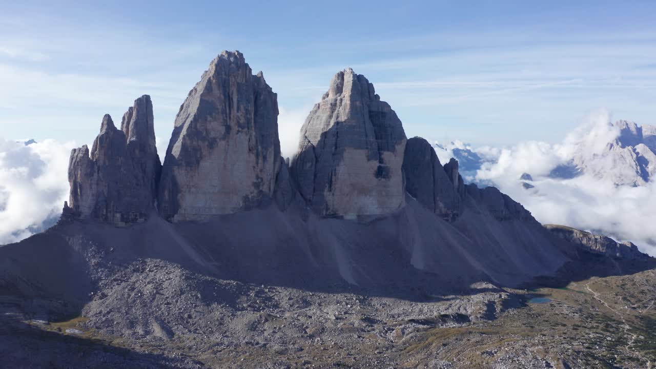 vuelo aéreo hacia las famosas torres tre cime di lavaredo durante el amanecer con un denso paisaje nublado en el fondo